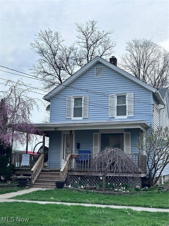 47 Swan St, Geneva, OH 44041 - farmhouse-style home with a porch, a chimney, and a front yard