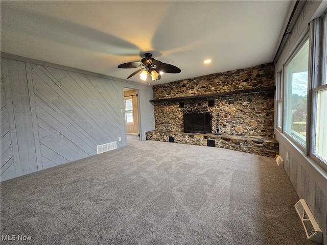 unfurnished living room featuring carpet flooring and wooden walls