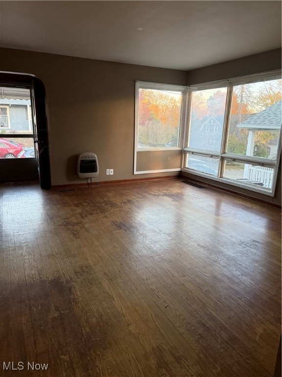 unfurnished room with dark wood-type flooring and heating unit