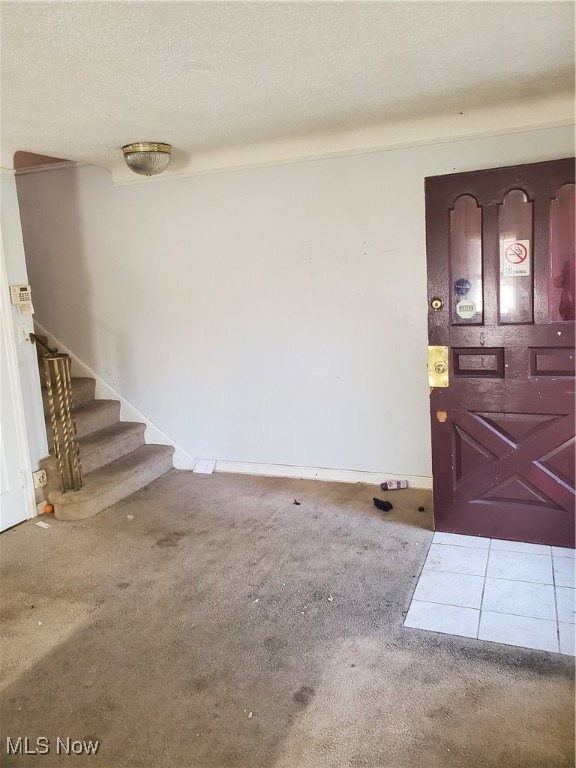 foyer featuring carpet floors and a textured ceiling