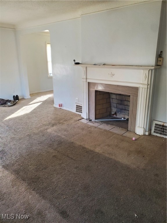 unfurnished living room featuring carpet flooring and a textured ceiling