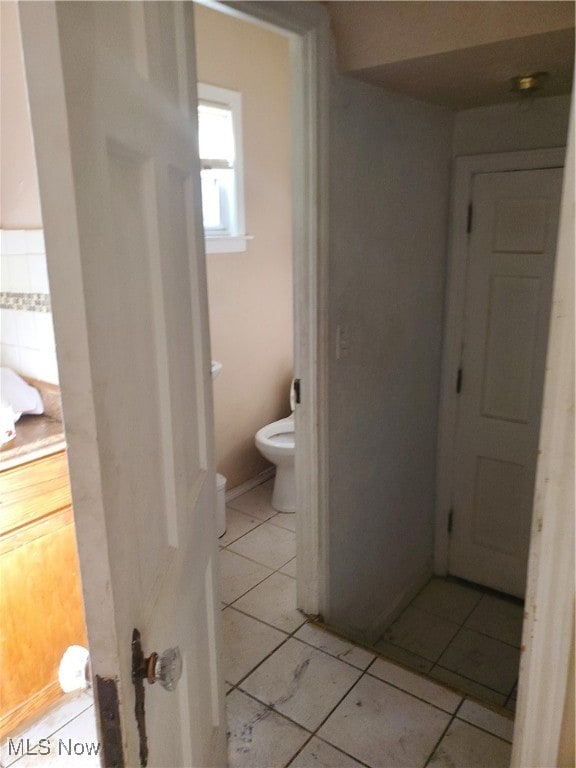 bathroom featuring toilet and tile patterned flooring