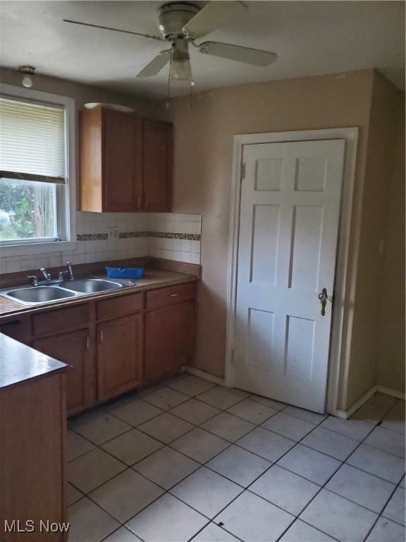 kitchen with ceiling fan, sink, tasteful backsplash, and light tile patterned flooring