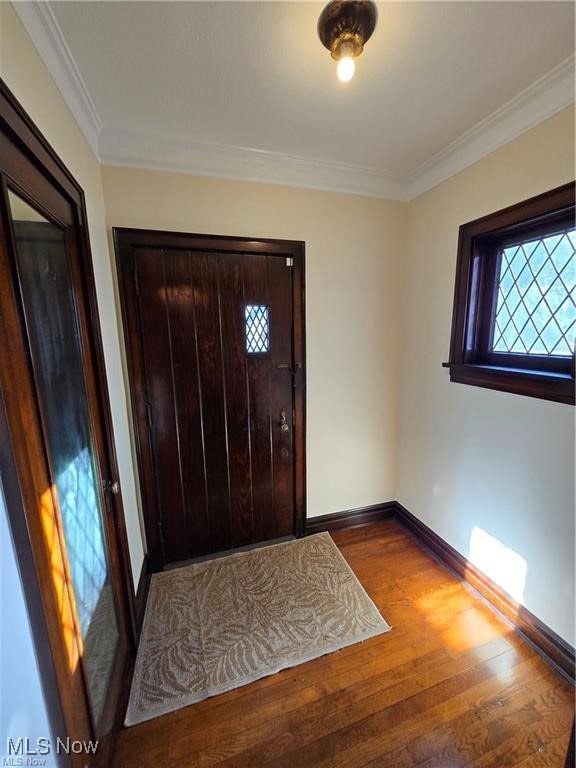 entrance foyer with hardwood / wood-style flooring and crown molding