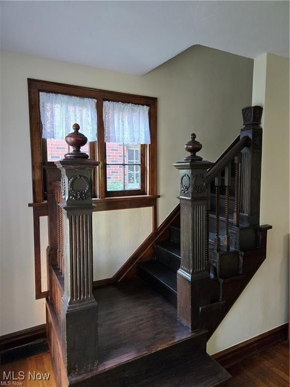 stairs with vaulted ceiling and hardwood / wood-style flooring