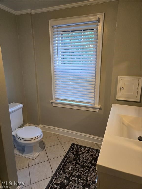 bathroom with toilet, vanity, tile patterned floors, and crown molding