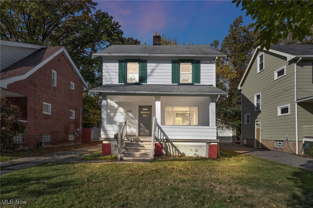 view of front property featuring a lawn and covered porch