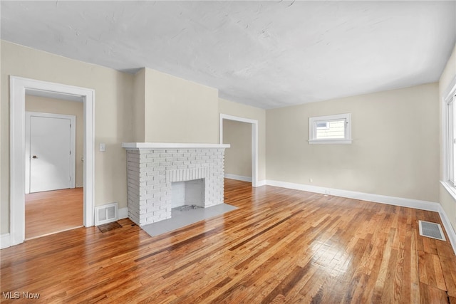 unfurnished living room with a fireplace and light hardwood / wood-style flooring