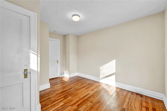 empty room with hardwood / wood-style flooring