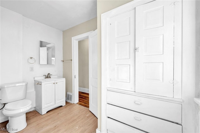 bathroom featuring hardwood / wood-style flooring, vanity, and toilet