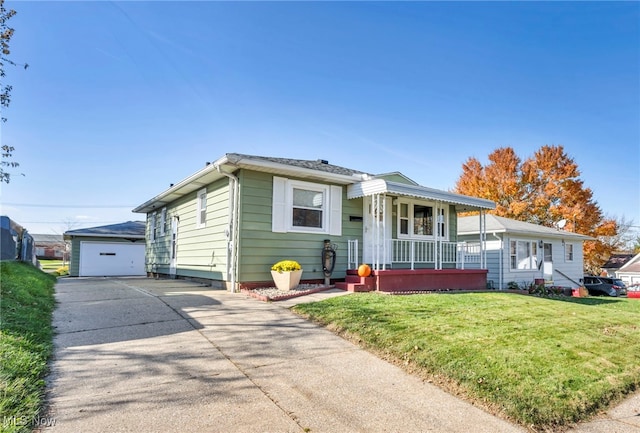 single story home featuring covered porch, a garage, a front lawn, and an outbuilding