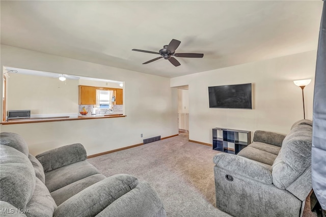 living room featuring light carpet and ceiling fan