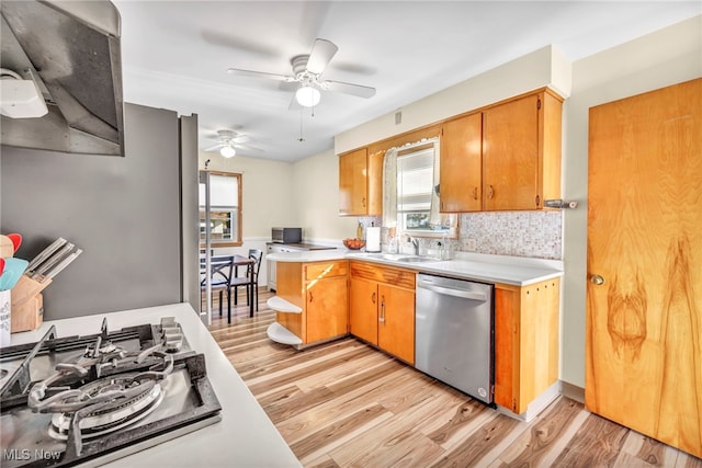 kitchen featuring stainless steel appliances, light hardwood / wood-style floors, tasteful backsplash, and ceiling fan