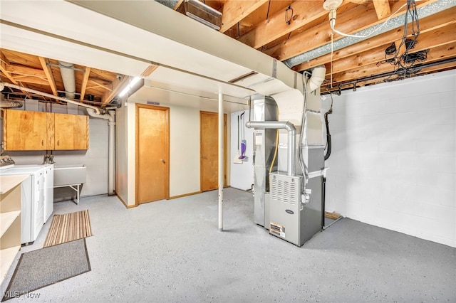 basement with heating unit and washer and clothes dryer