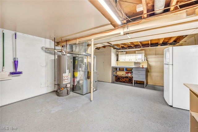 basement featuring gas water heater, white refrigerator, and heating unit