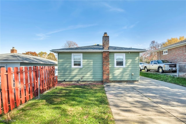 rear view of house featuring a patio and a lawn