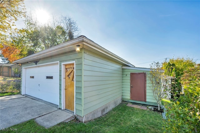 view of outdoor structure with a garage and a lawn