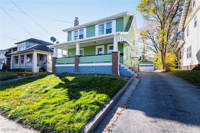 view of front of property featuring a porch, a garage, and a front lawn