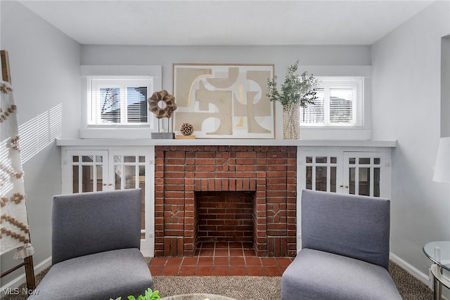 sitting room featuring a fireplace, plenty of natural light, and carpet