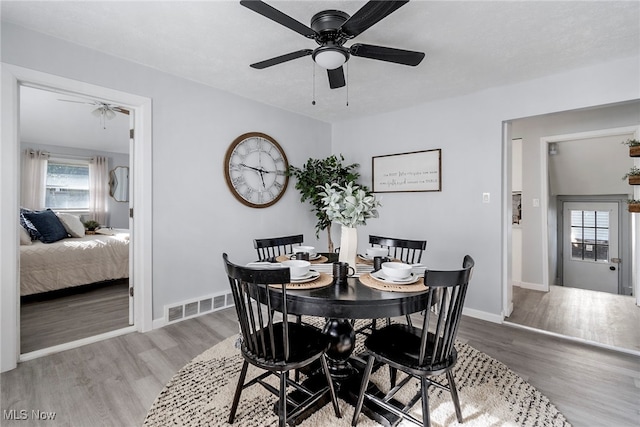 dining space with wood-type flooring and ceiling fan