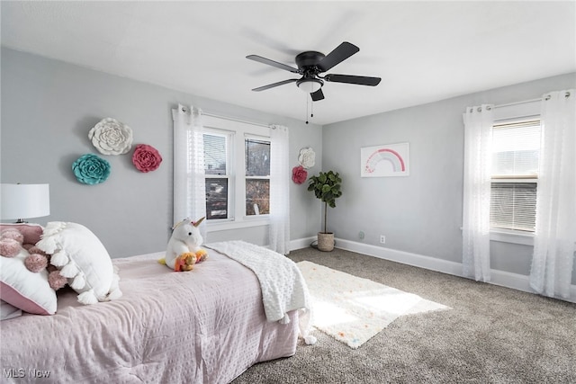 carpeted bedroom featuring multiple windows and ceiling fan