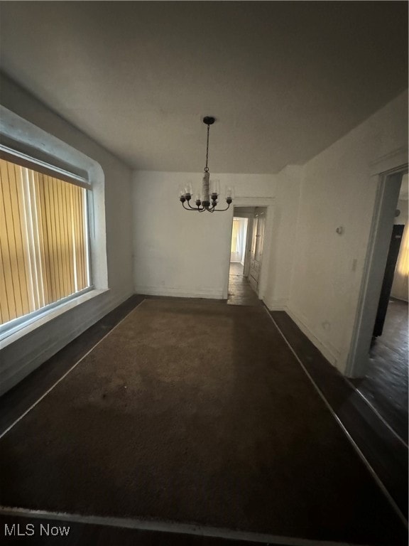 unfurnished dining area with a notable chandelier