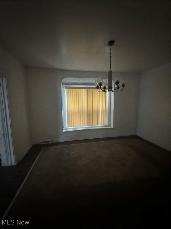 unfurnished dining area with carpet and an inviting chandelier