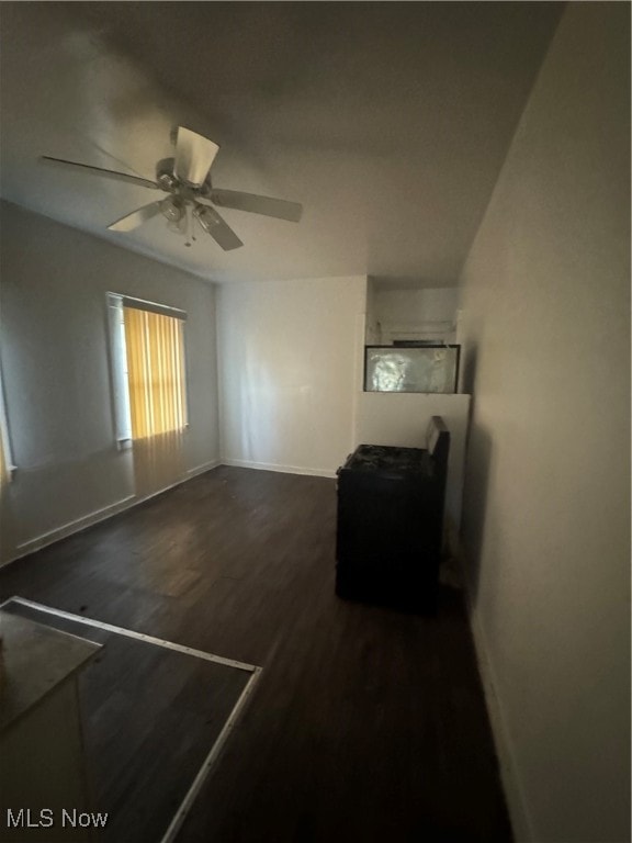 empty room with dark wood-type flooring and ceiling fan