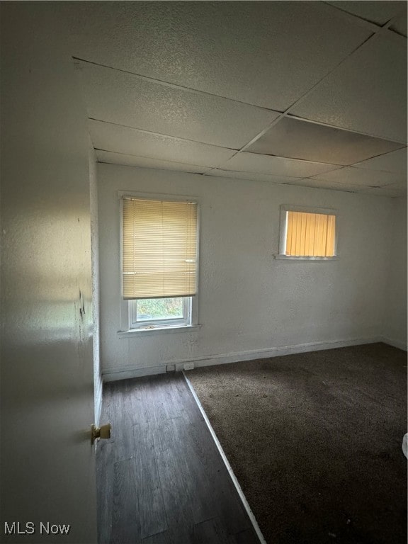 unfurnished room with dark hardwood / wood-style floors and a paneled ceiling