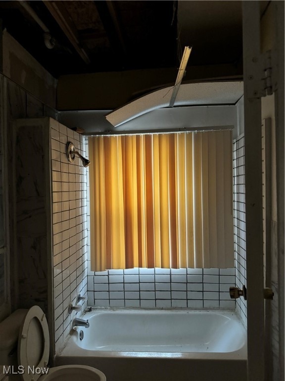 bathroom with shower / bath combination and toilet