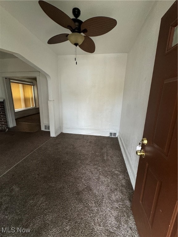 unfurnished room featuring dark colored carpet and ceiling fan