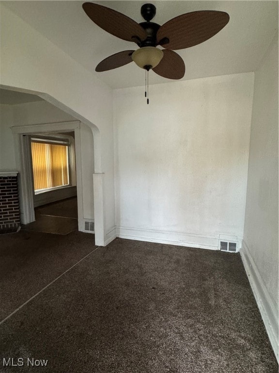 interior space with ceiling fan and dark colored carpet