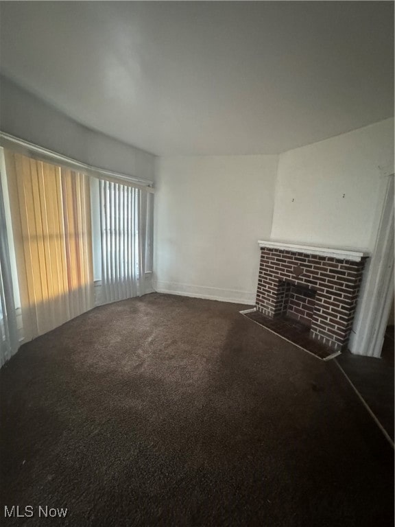 unfurnished living room with a fireplace and carpet floors