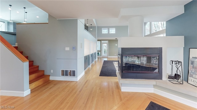 corridor with a high ceiling and light wood-type flooring