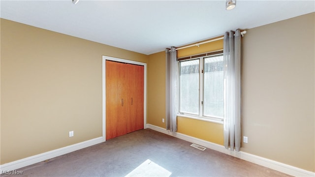 unfurnished bedroom with a closet and light colored carpet