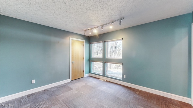 carpeted spare room featuring a textured ceiling