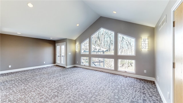 spare room with carpet and vaulted ceiling