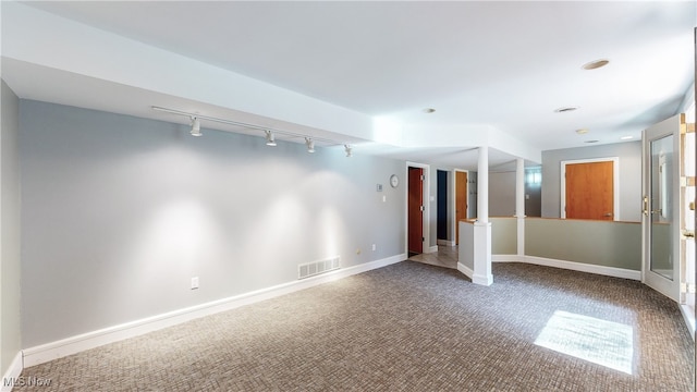 carpeted spare room featuring track lighting and ornate columns