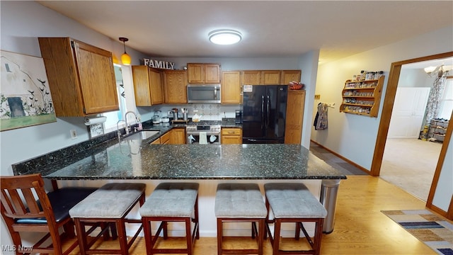 kitchen with sink, decorative light fixtures, a kitchen breakfast bar, and stainless steel appliances