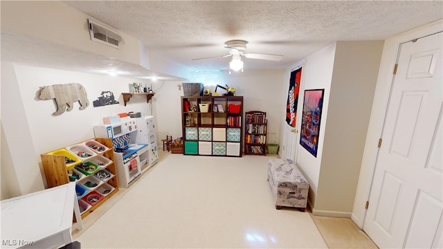 playroom featuring ceiling fan and a textured ceiling