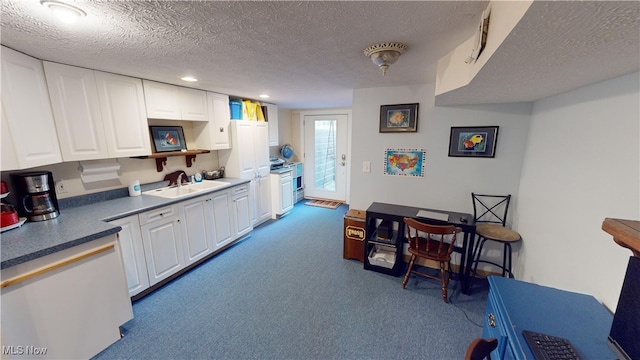 kitchen with light carpet, a textured ceiling, white cabinetry, and sink