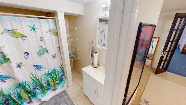 bathroom with a shower with curtain, vanity, and tile patterned floors