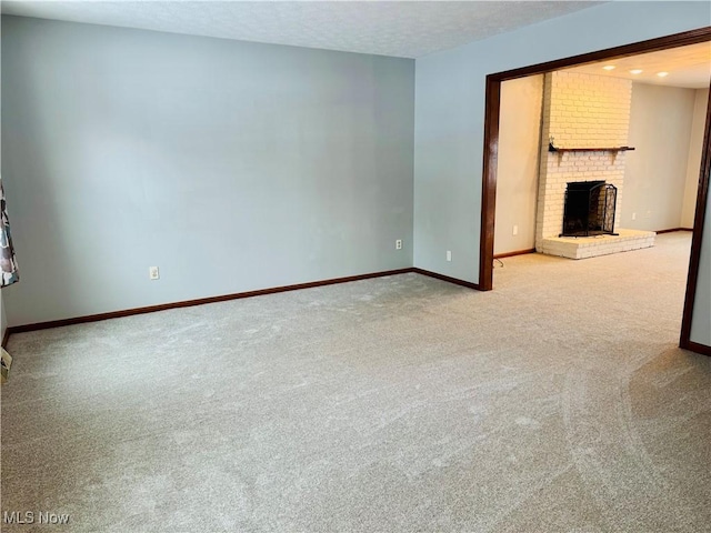 unfurnished living room with a fireplace, carpet, and a textured ceiling