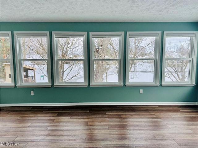 unfurnished room featuring a textured ceiling and dark hardwood / wood-style floors