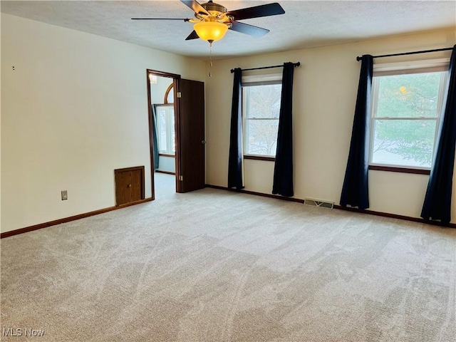 carpeted empty room featuring ceiling fan and a textured ceiling