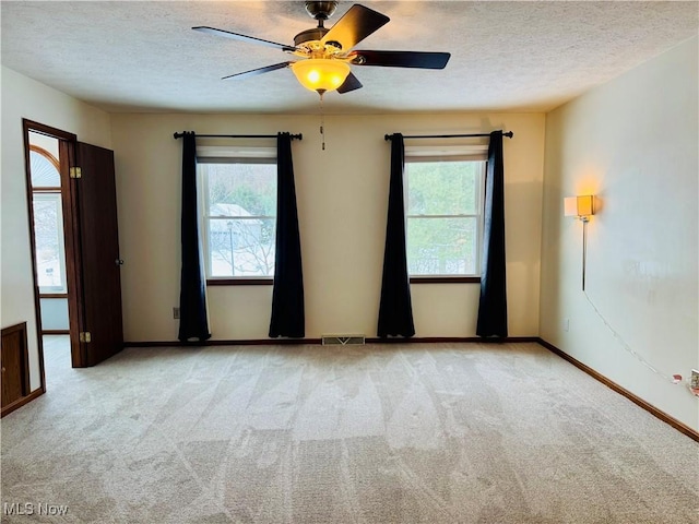 carpeted empty room with a textured ceiling and ceiling fan