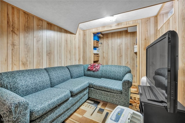 living room with wood walls and a textured ceiling