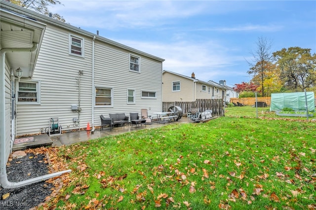 rear view of property featuring a lawn and a patio area