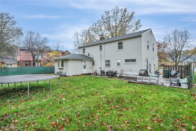 rear view of house featuring a trampoline, a yard, an outdoor hangout area, central air condition unit, and a patio area