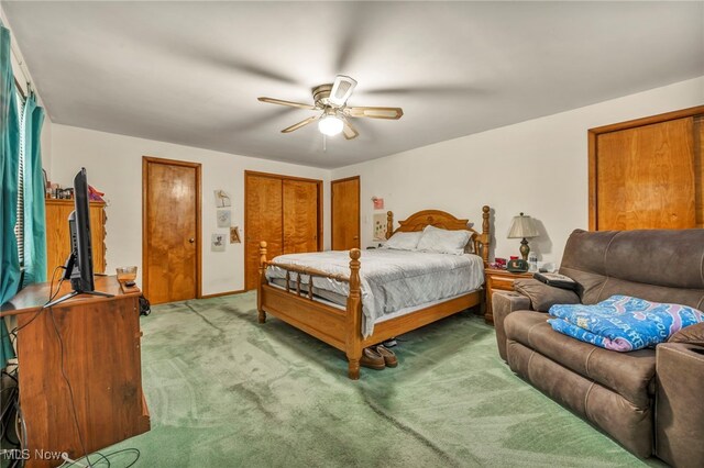 carpeted bedroom with multiple closets and ceiling fan